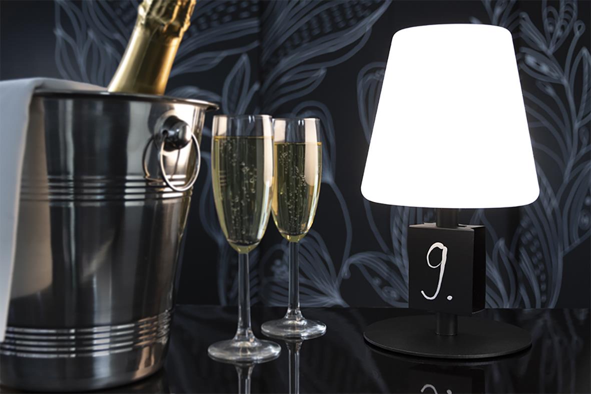 Bordslampa med griffeltavla, två champagneglas och en isbucket på ett bord