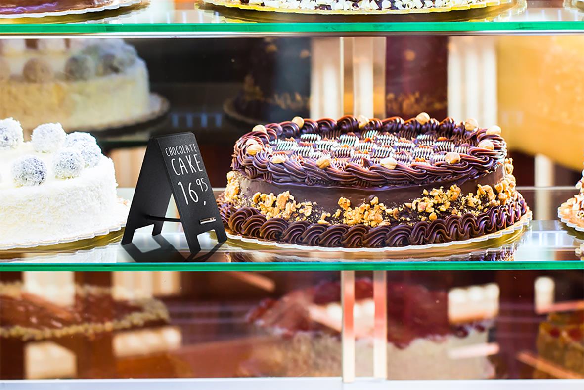 Små svart griffeltavla Securit Mini för bord, 8,5x5cm, placerad bland bakverk i ett kafé