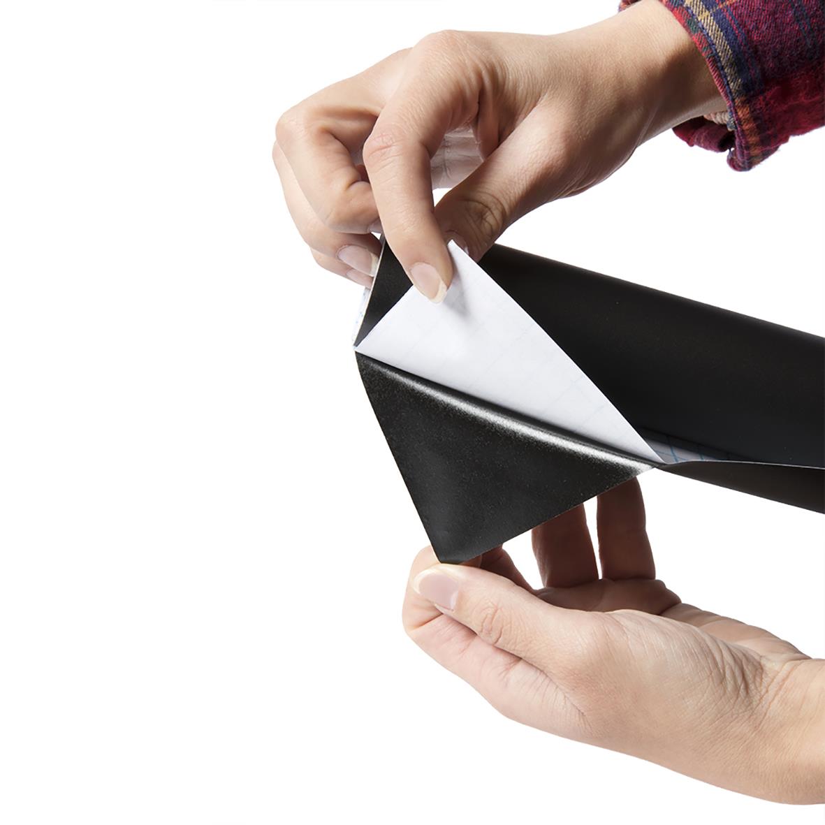 Person som applicerar självhäftande griffeltavla Securit på en vägg