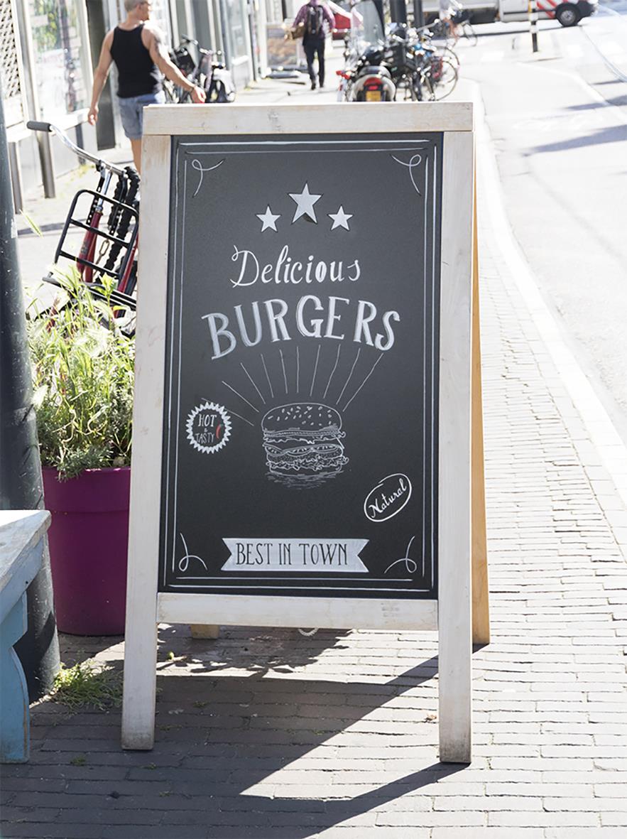 Gatuprata med svart tavla för matmeny, reklam för hamburgare, utomhusmiljö, skylt med skrivyta
