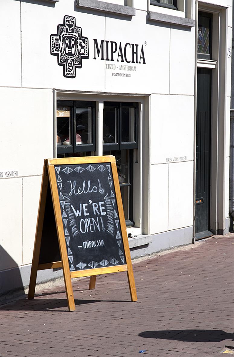 Gatuställ Securit Woody Furu Teak 58x87cm med skrivyta utanför byggnad med skylt