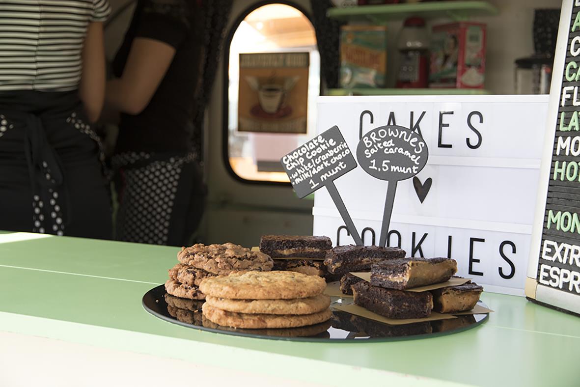 Skyltskylt med texten Cookies och bilder av kakor på ett bord