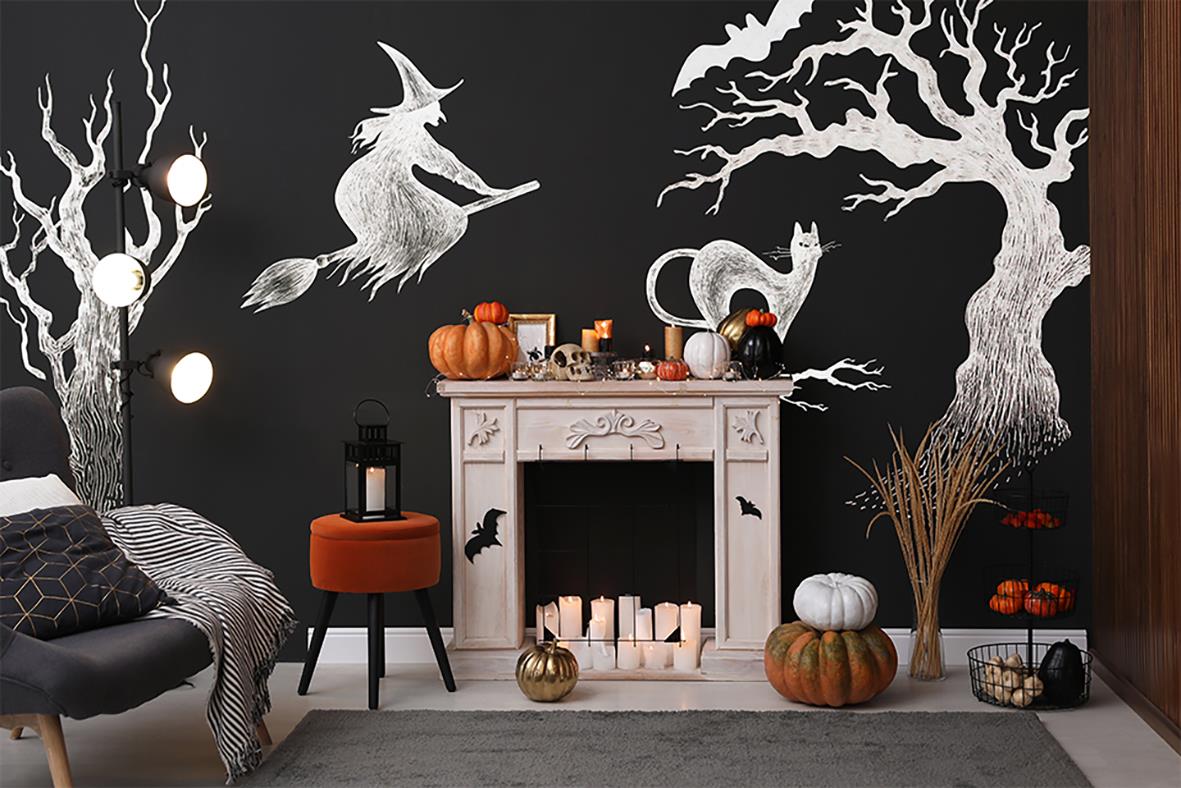 Svart väggfärg med vinter- och halloweenmotiv, inklusive träd, häst och uggla, i ett rum med möbler och dekorationer