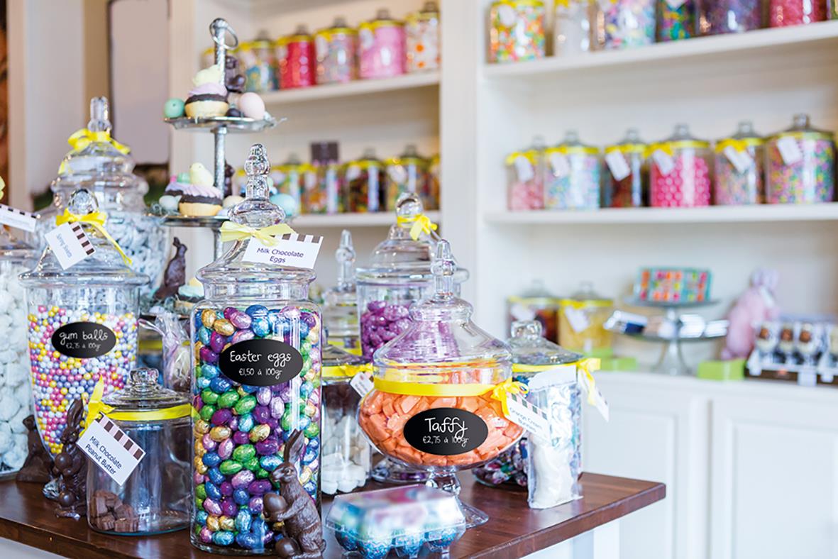 Färgglada godisbord med glasburkar fyllda med godis i en butik eller café