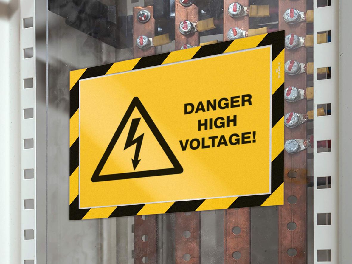 " för hög spänning med gul bakgrund och svart text, placerad i ett elskåp"