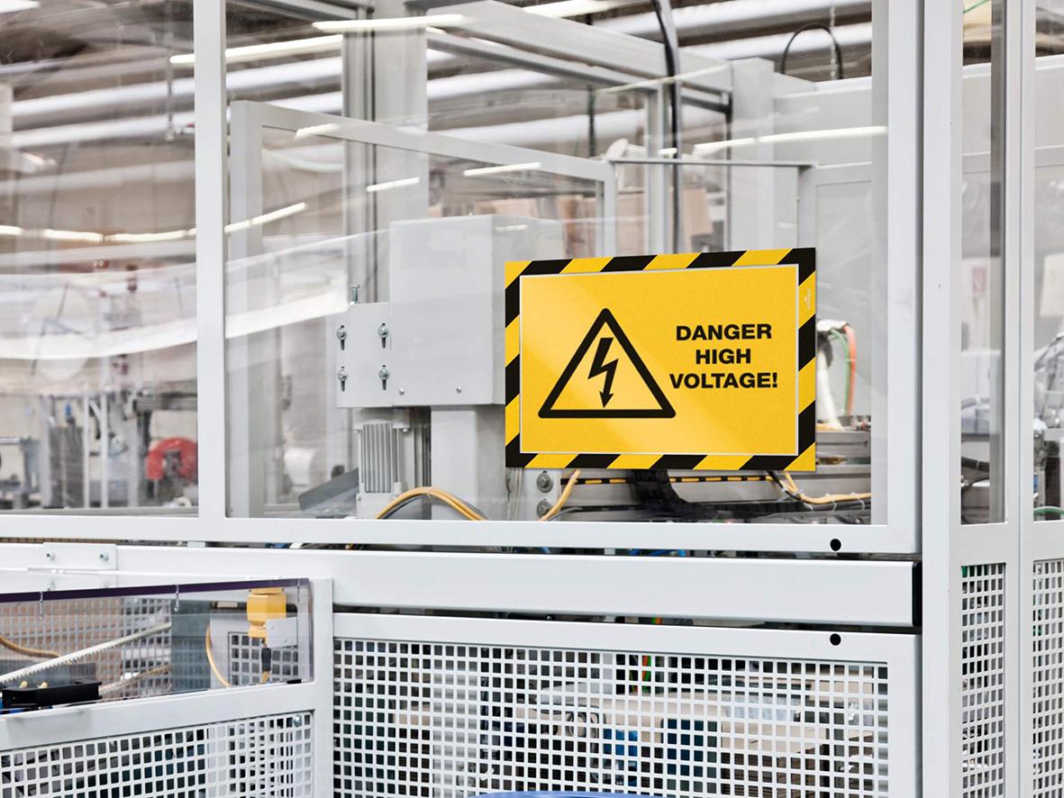 Gult och svart säkerhetsvarningsskylt med text DANGER HIGH VOLTAGE i ett skyltfönster