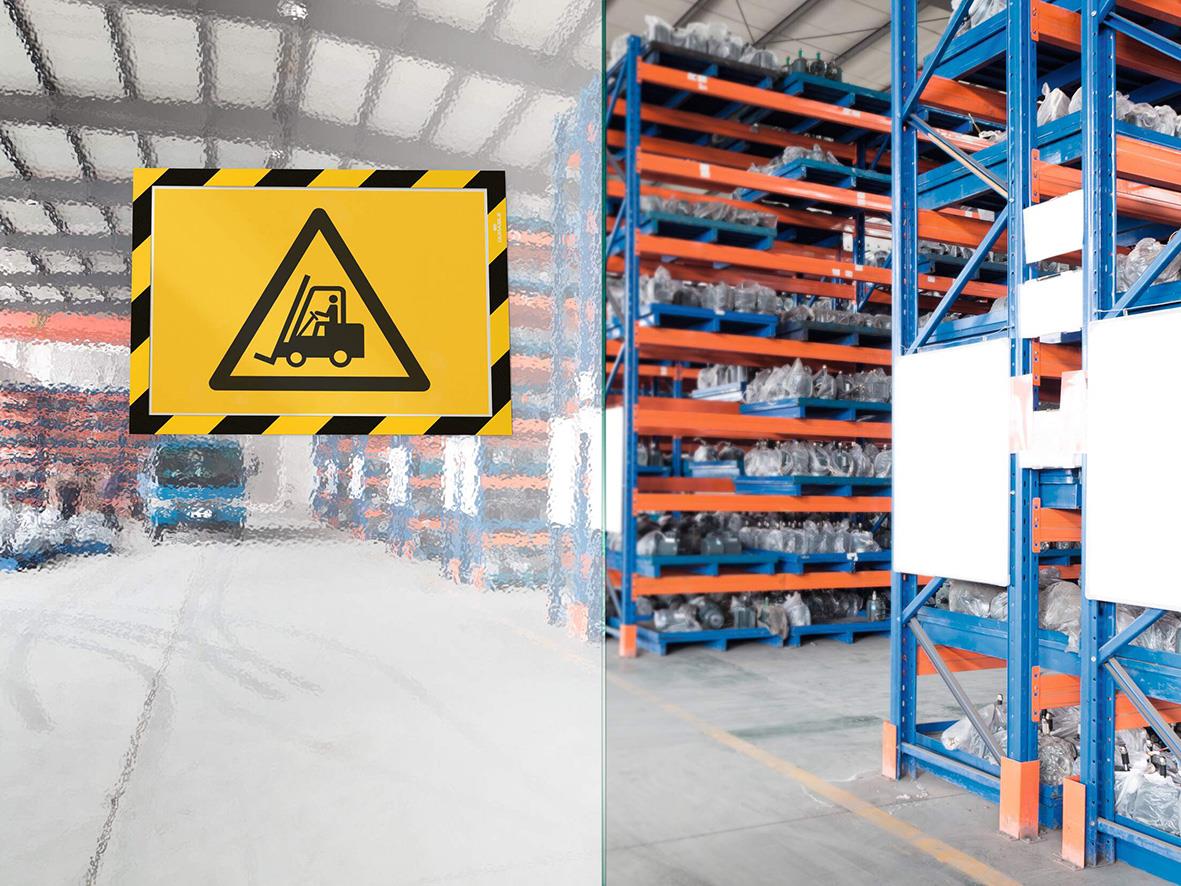 Självhäftande säkerhetsram i gul och svart med varningssymbol i lagerlokal