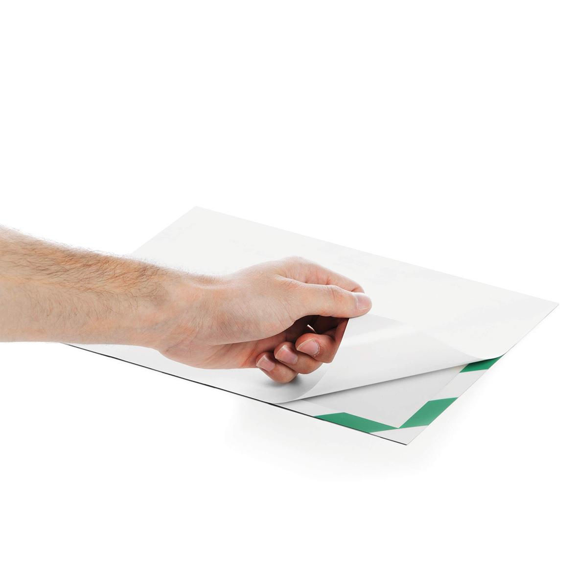 Person som applicerar självhäftande Duraframe säkerhetsfilm i grönt/vitt på en A4-ram