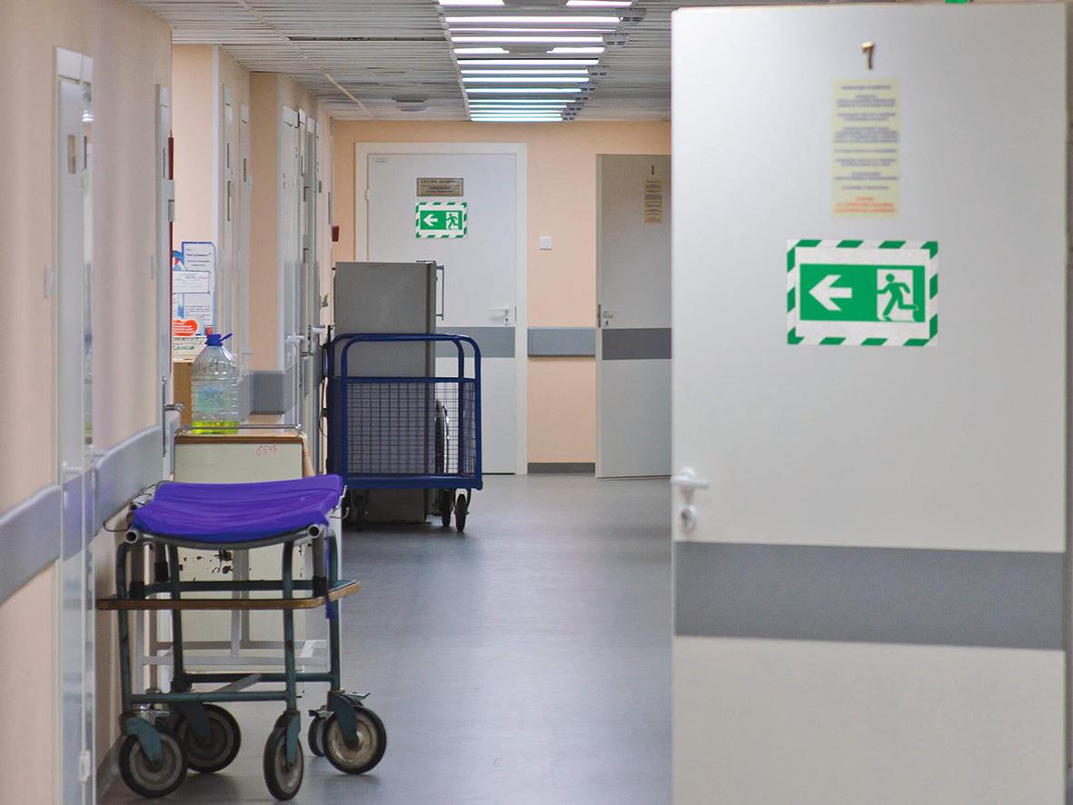 Väntutrymme på sjukhus med rullstol och skylt för nödsituation