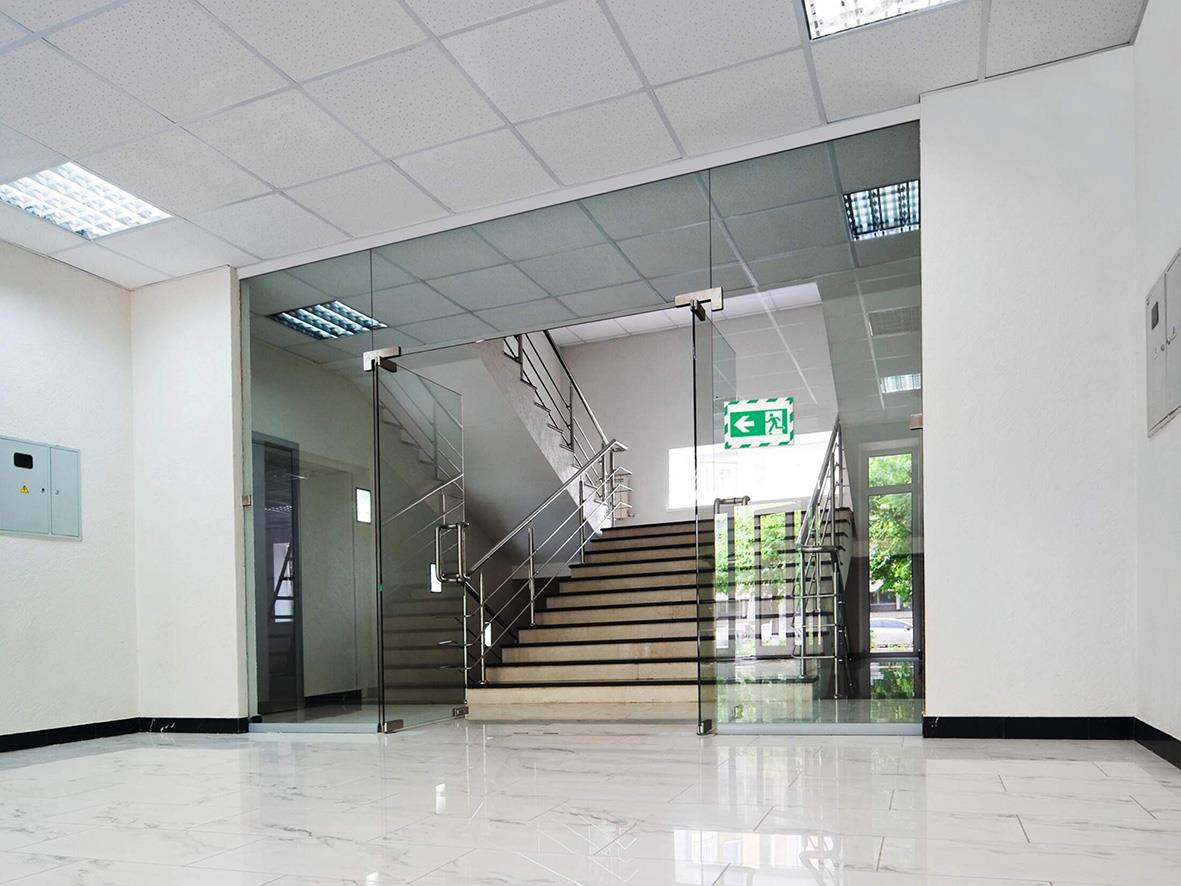 Inforam Duraframe självhäftande säkerhetsfolie i grönt och vitt på A4, monterad vid trappa i inomhusmiljö