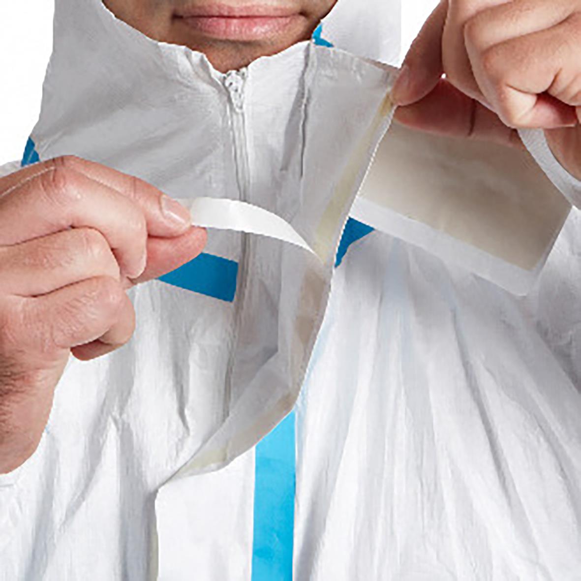 Person som bär en vit Tyvek 600 Plus korttidsoverall och håller i dragkedjan