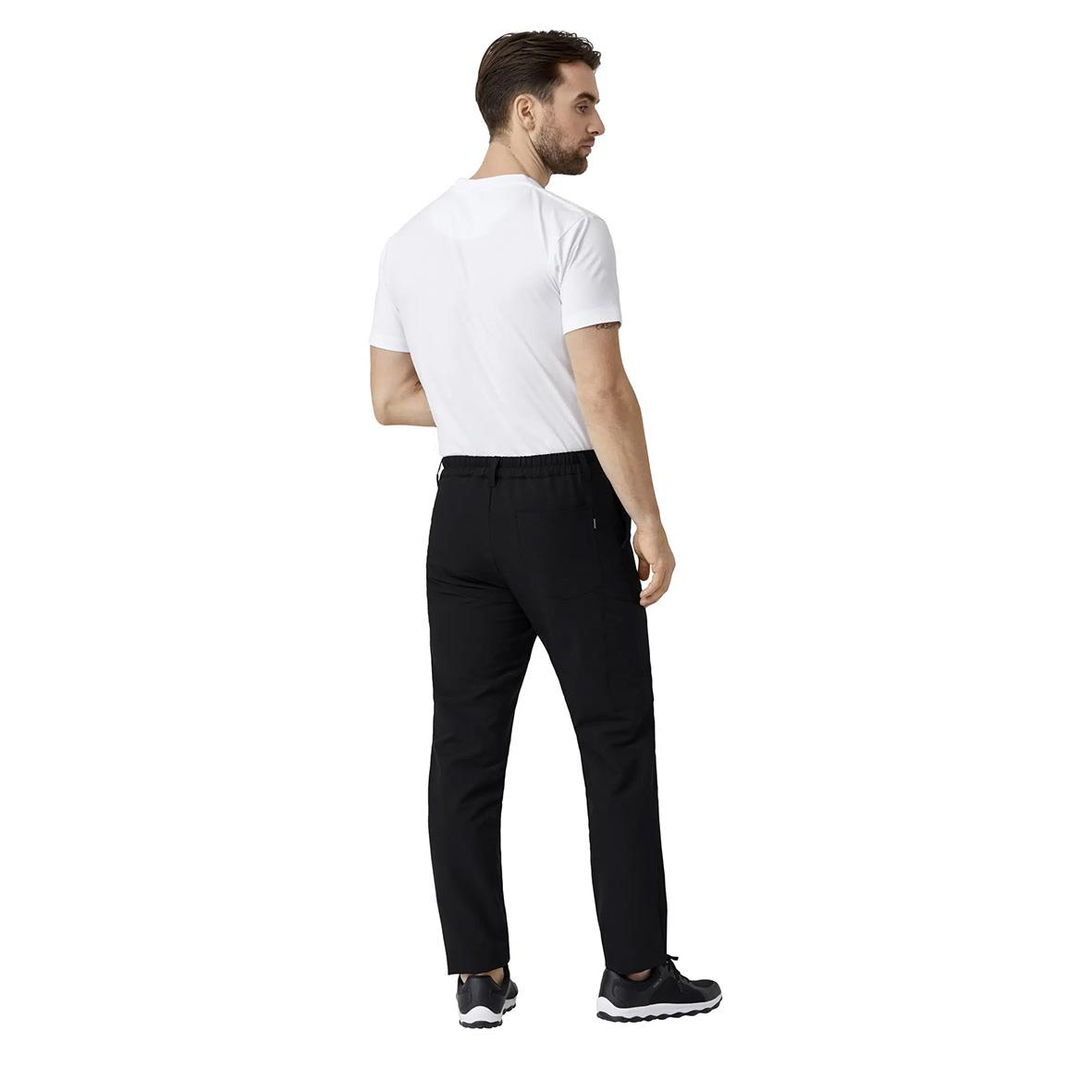 Man i vita T-shirt och svarta byxor som står med ryggen mot kameran