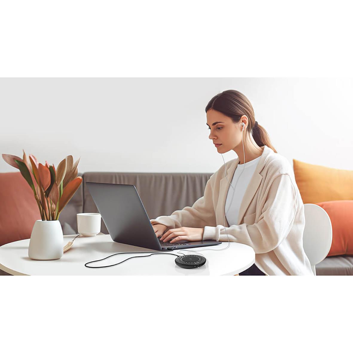 Kvinna använder konferensmikrofon Boya Nobby vid laptop i vardagsrum