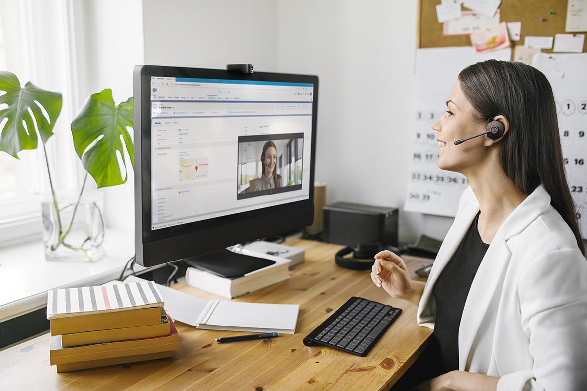 Kvinna med headset Jabra Engage 75 SE Convertible Bluetooth under videokonferens i kontorsmiljö