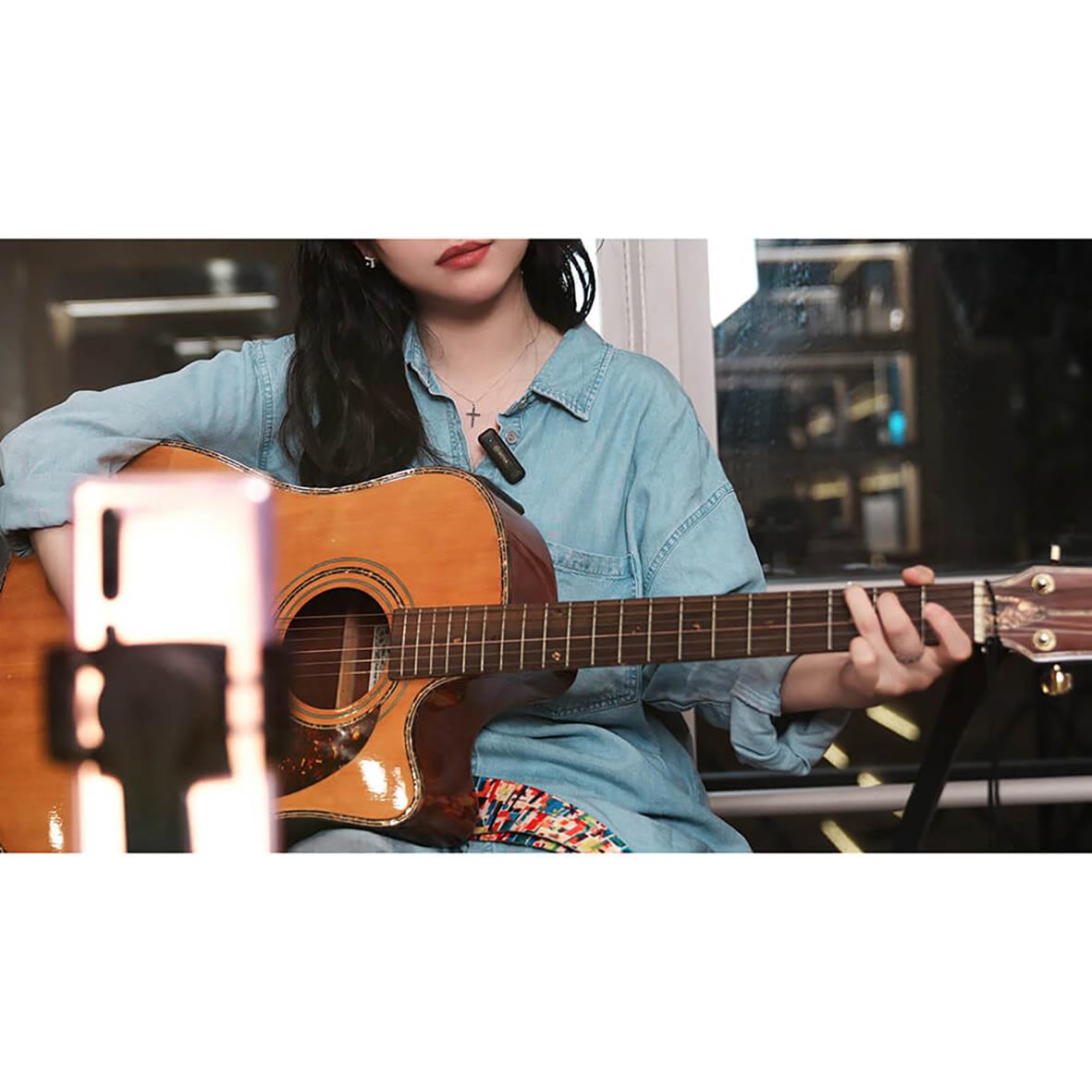 Kvinna spelar gitarr med trådlöst mikrofon BY-WM3 för Lightning