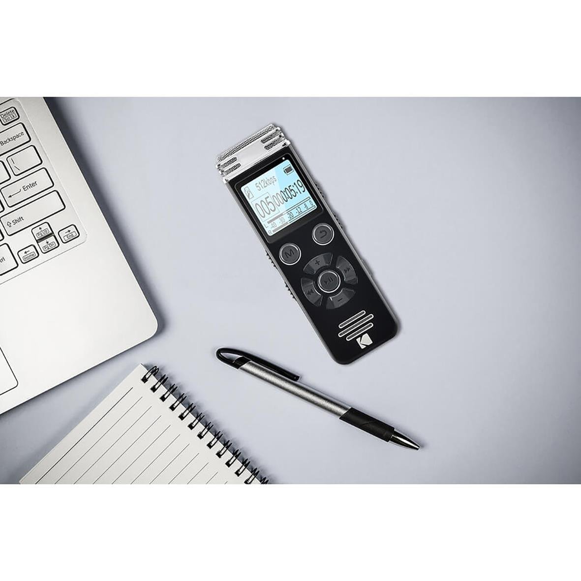 Diktafon Kodak VRC450 placerad på ett skrivbord tillsammans med en laptop, penna och anteckningsblock