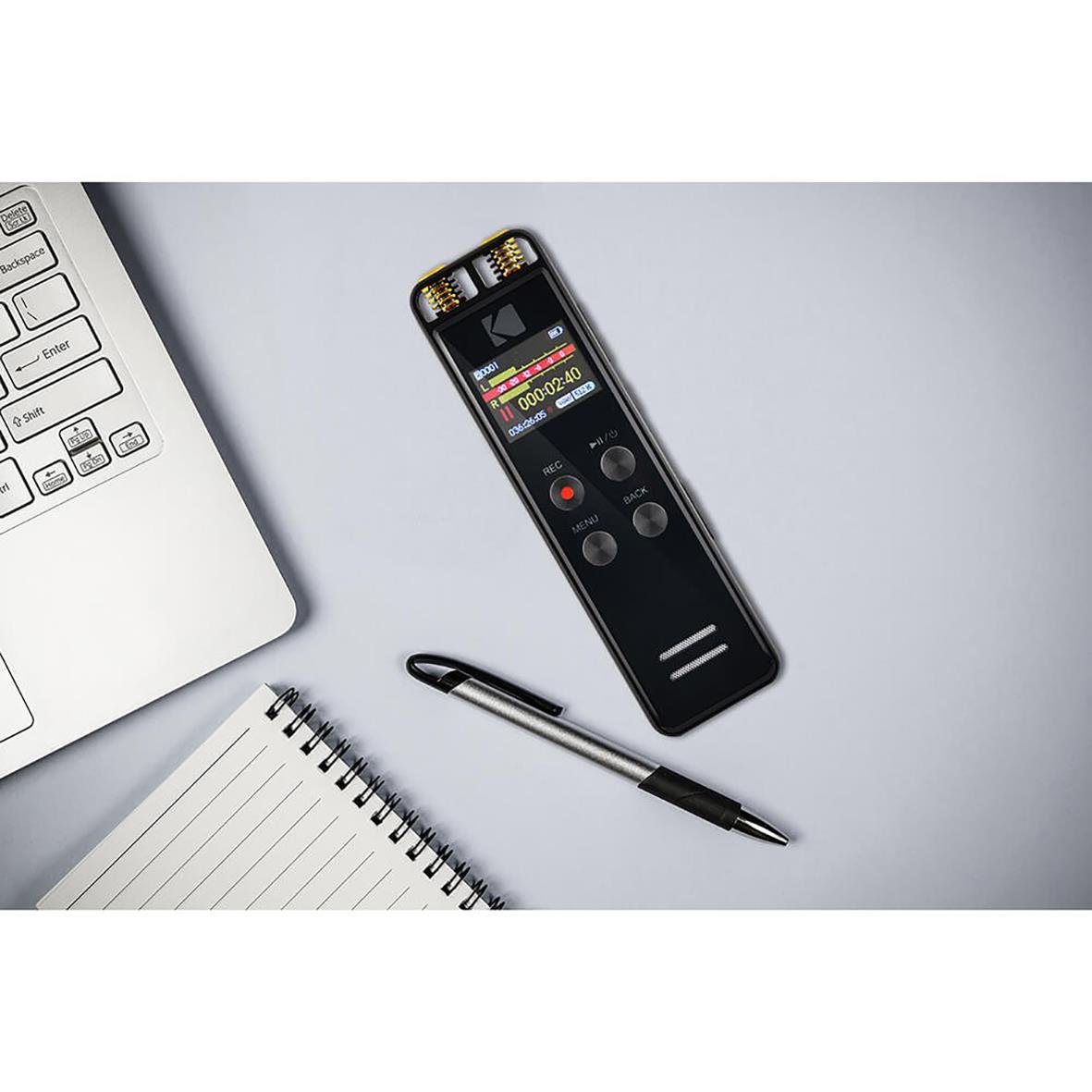 Diktafon Kodak VRC550 placerad på ett skrivbord bredvid en penna, ett tangentbord och ett anteckningsblock