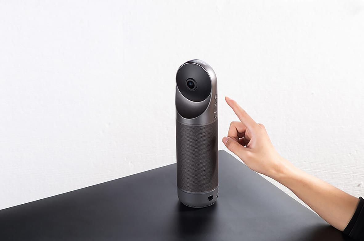 Konferenskamera Kandao Meeting Pro på bord med hand som pekar mot den