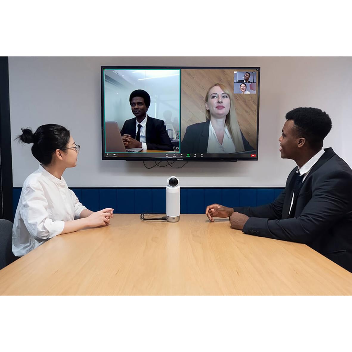 Tre personer i ett konferensrum använder Kandao Meeting S-kameran för videomöte, med en stor skärm som visar deltagare online.