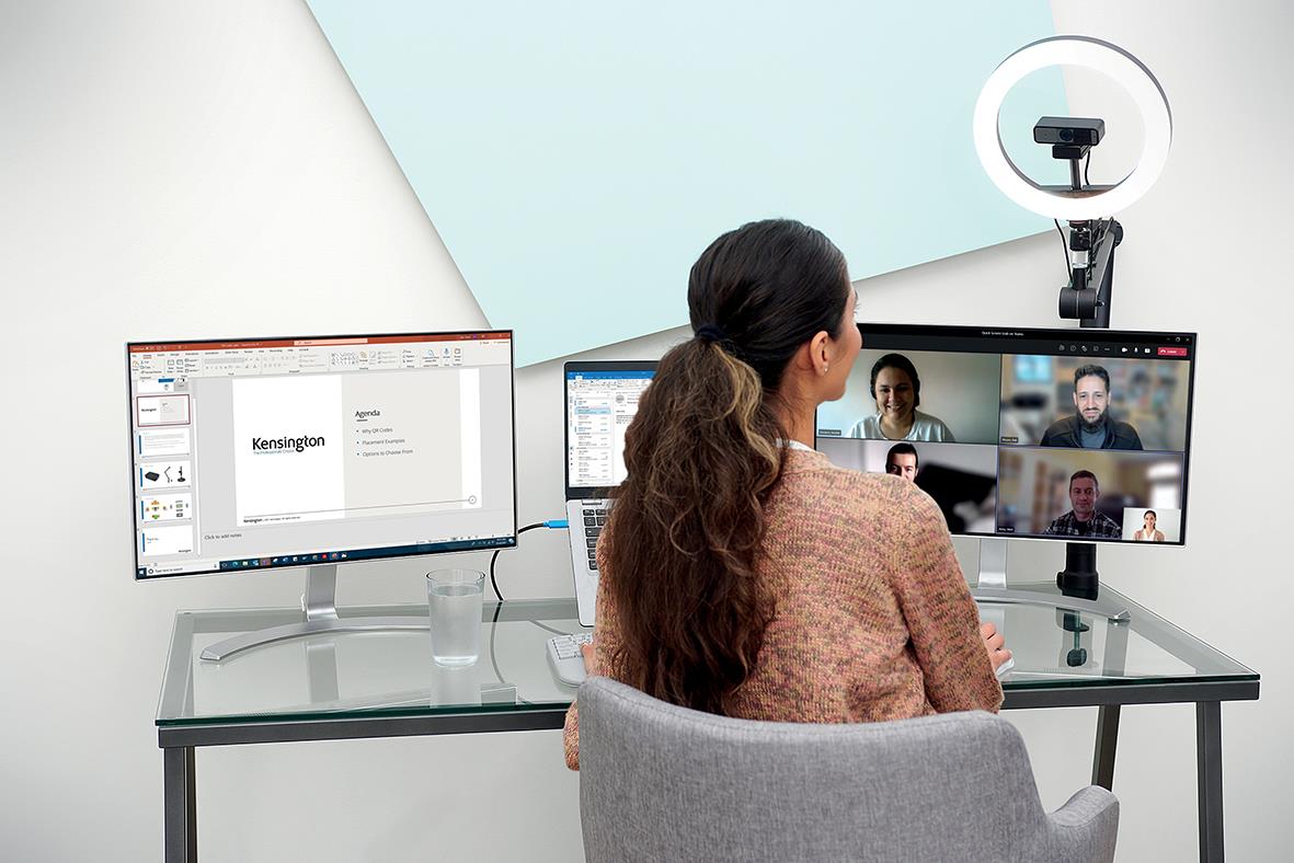 Kvinna använder webbkamera Kensington W2050 1080P för videokonferens vid skrivbord