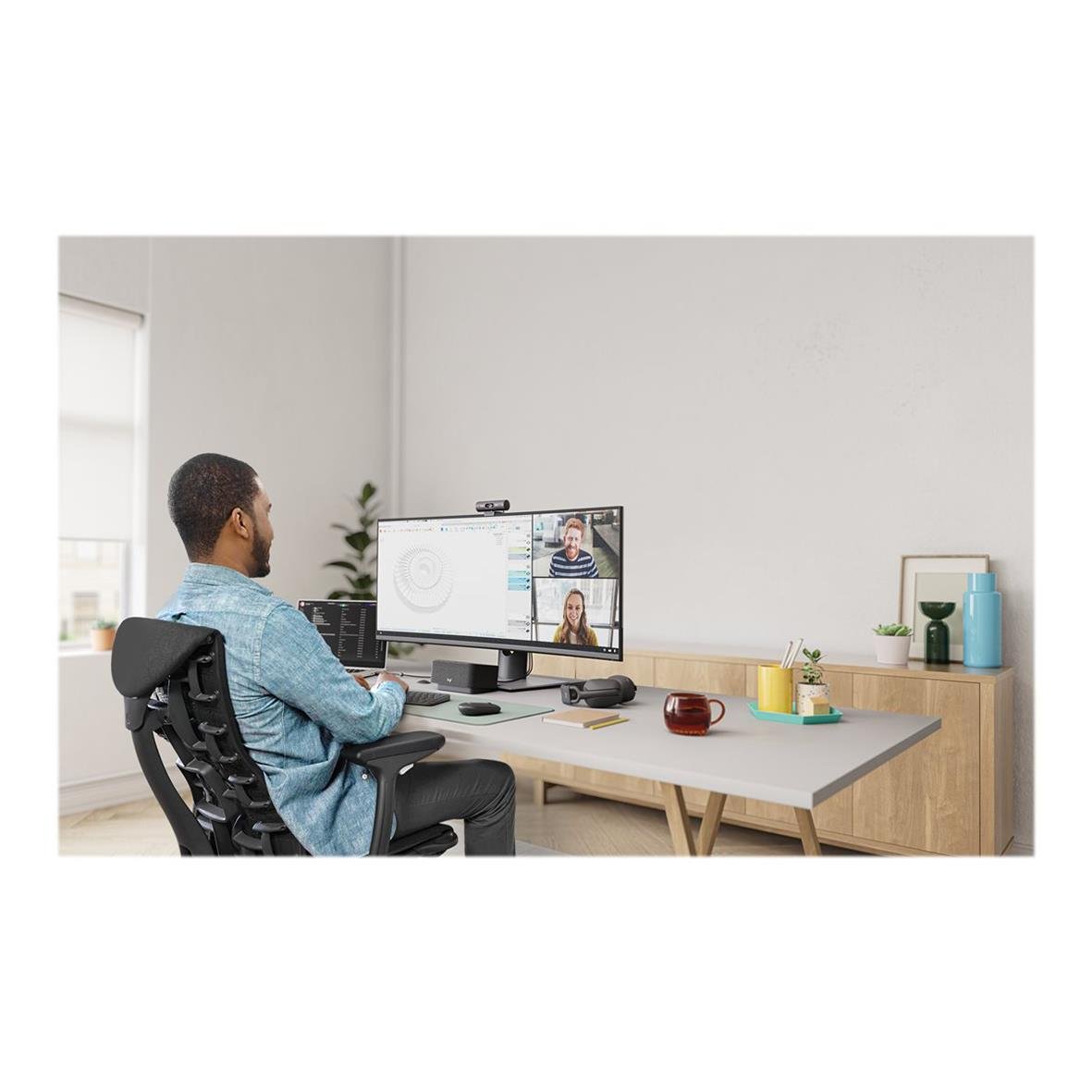 Person som använder Logitech Brio 505 webbkamera vid dator i ett hemkontor