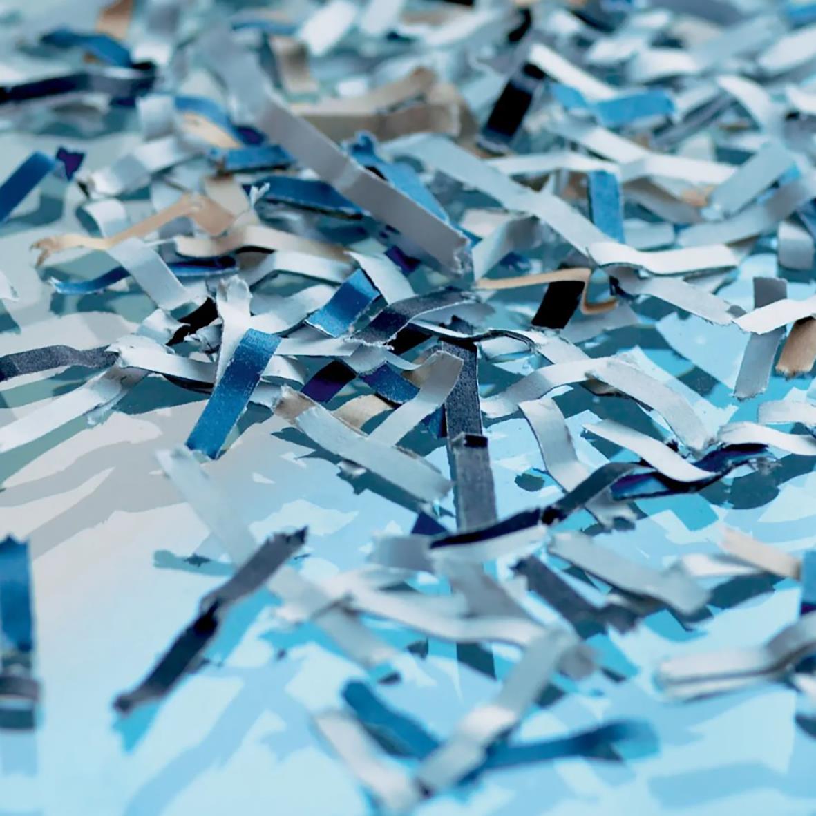 Krossade blå och vit papperstrimlor från en dokumentförstörare Dahle Team 410 P4