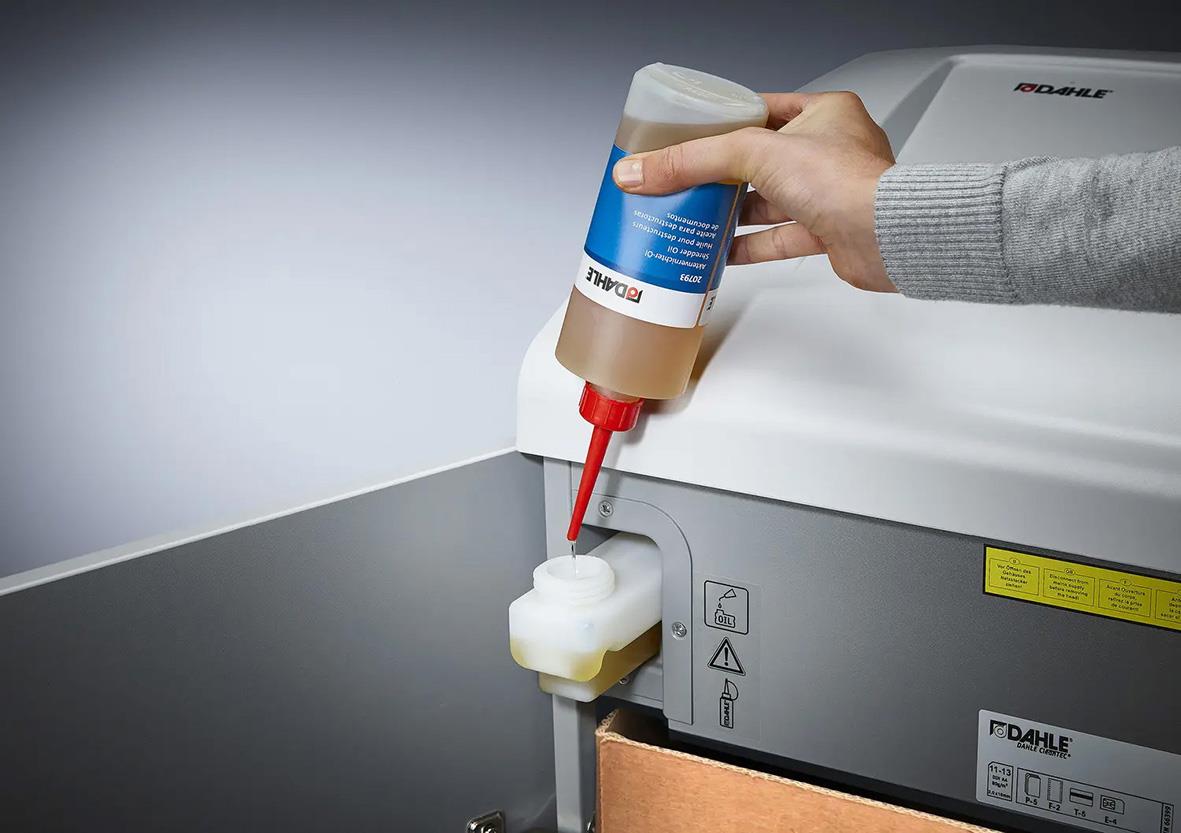 Person fyller dokumentförstörare Dahle Team 710 P7 med olja