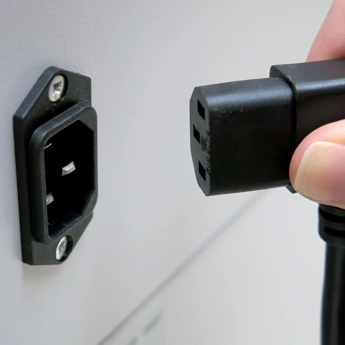 Person som kopplar in en Dahle Volume Pro 719 P7 dokumentförstörare till ett eluttag