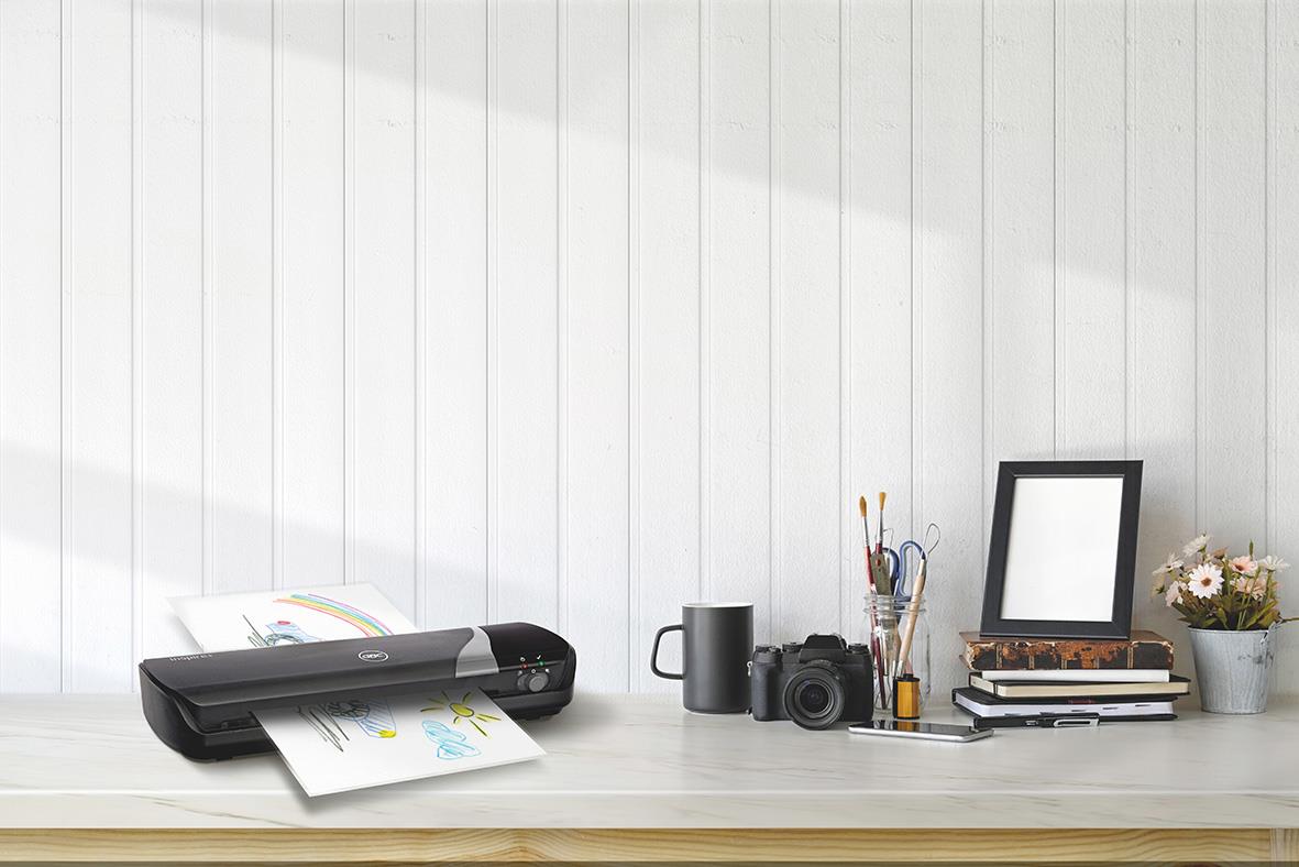Lamineringsmaskin GBC Inspire+ Craftpack svart A4 på skrivbord med kamera och växt