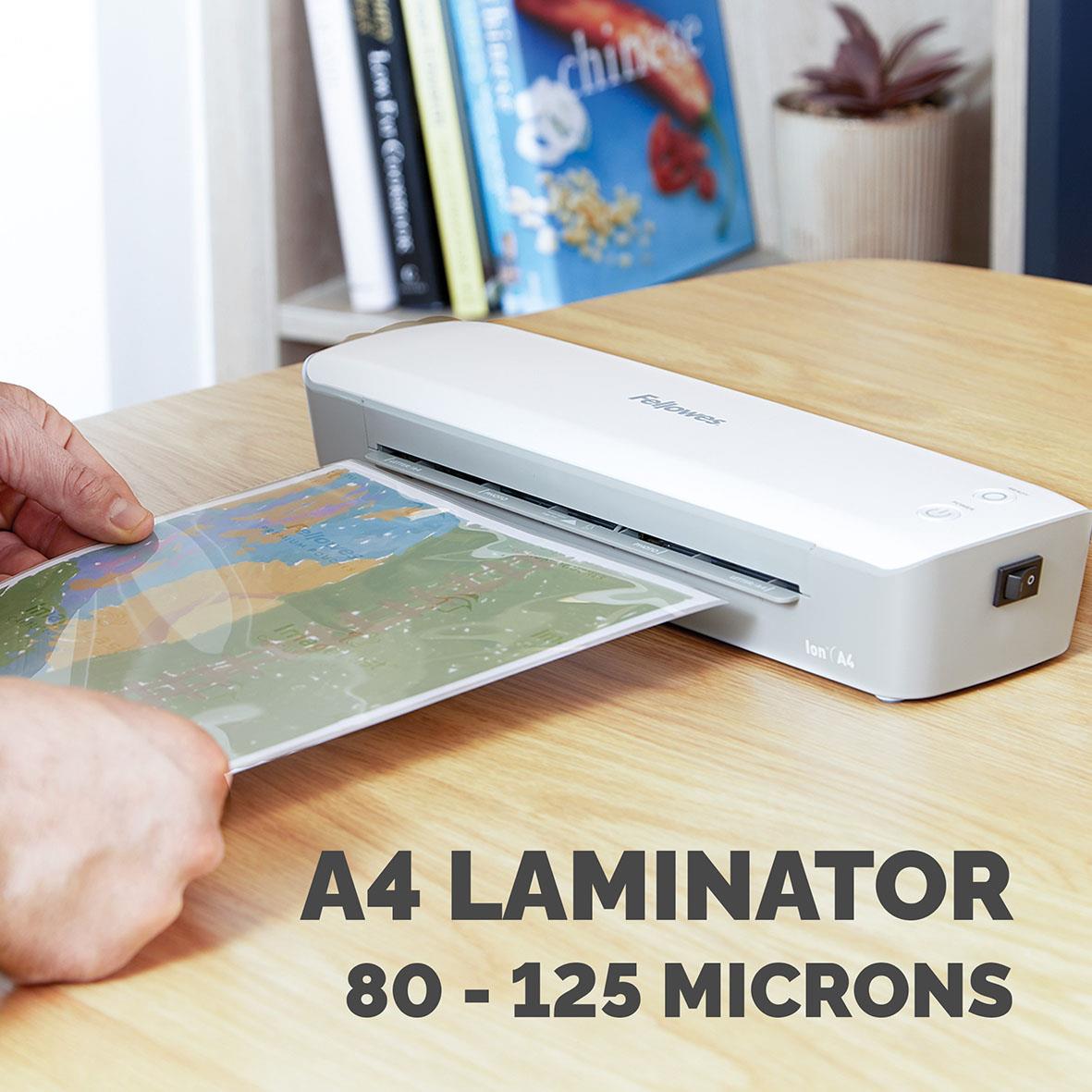 Person laminates a colorful map with Fellowes Ion A4 lamineringsmaskin på ett skrivbord