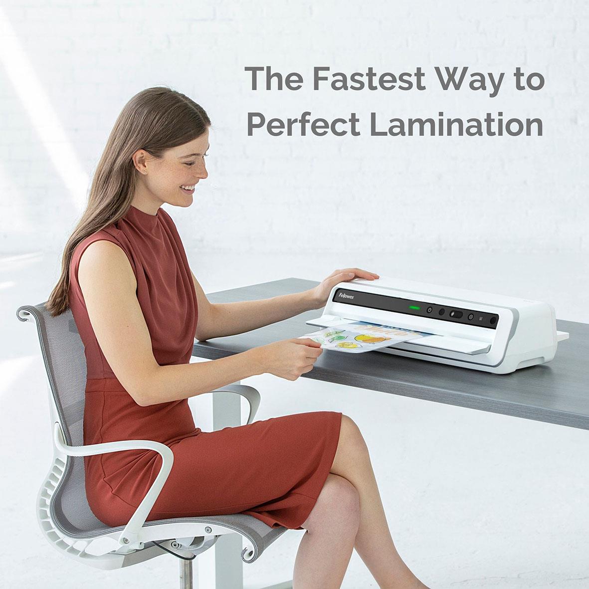 Kvinna laminering med Fellowes Venus A3 lamineringsmaskin på skrivbordet