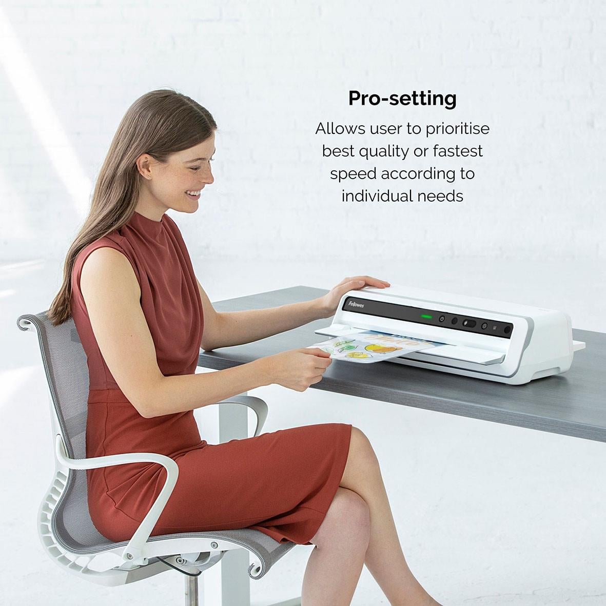 Kvinna använder lamineringsmaskin Fellowes Venus A3 med pro-inställning för snabb lamineringsprocess