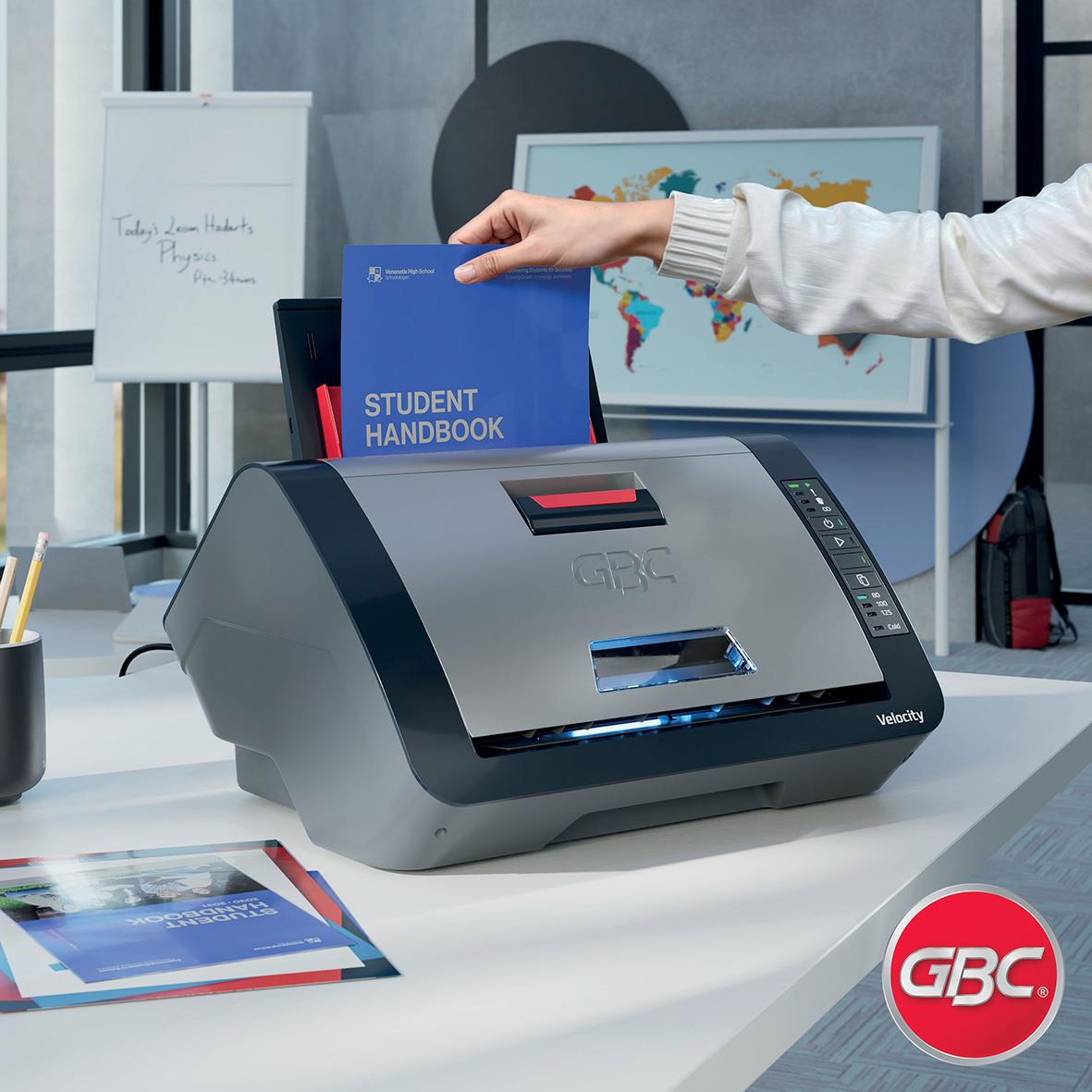 Person laminates ett blått studenthandbok med GBC Velocity laminator i ett kontorsmiljö