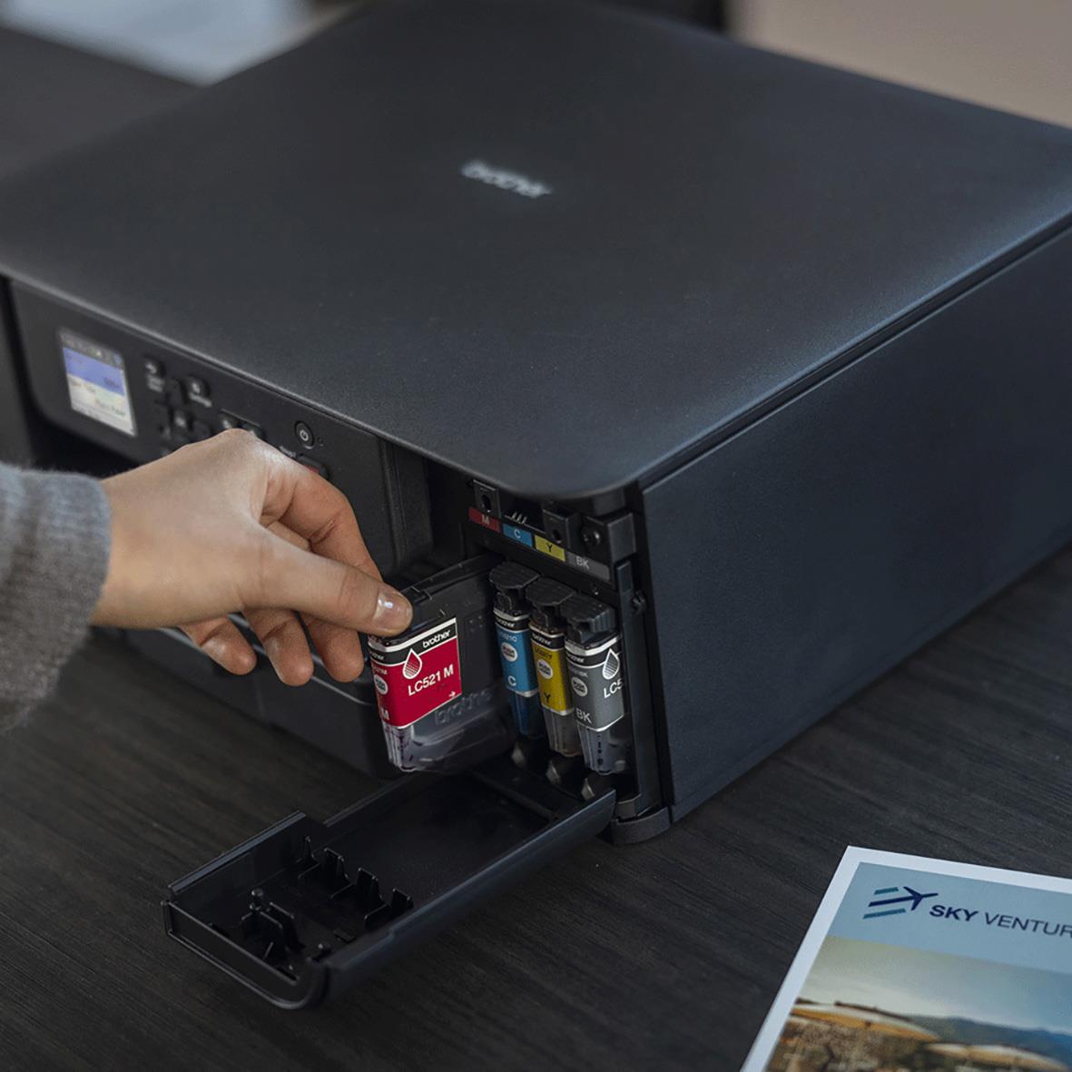 Person som fyller på bläck i en multifunktionsskrivare Brother DCP-J1310DW