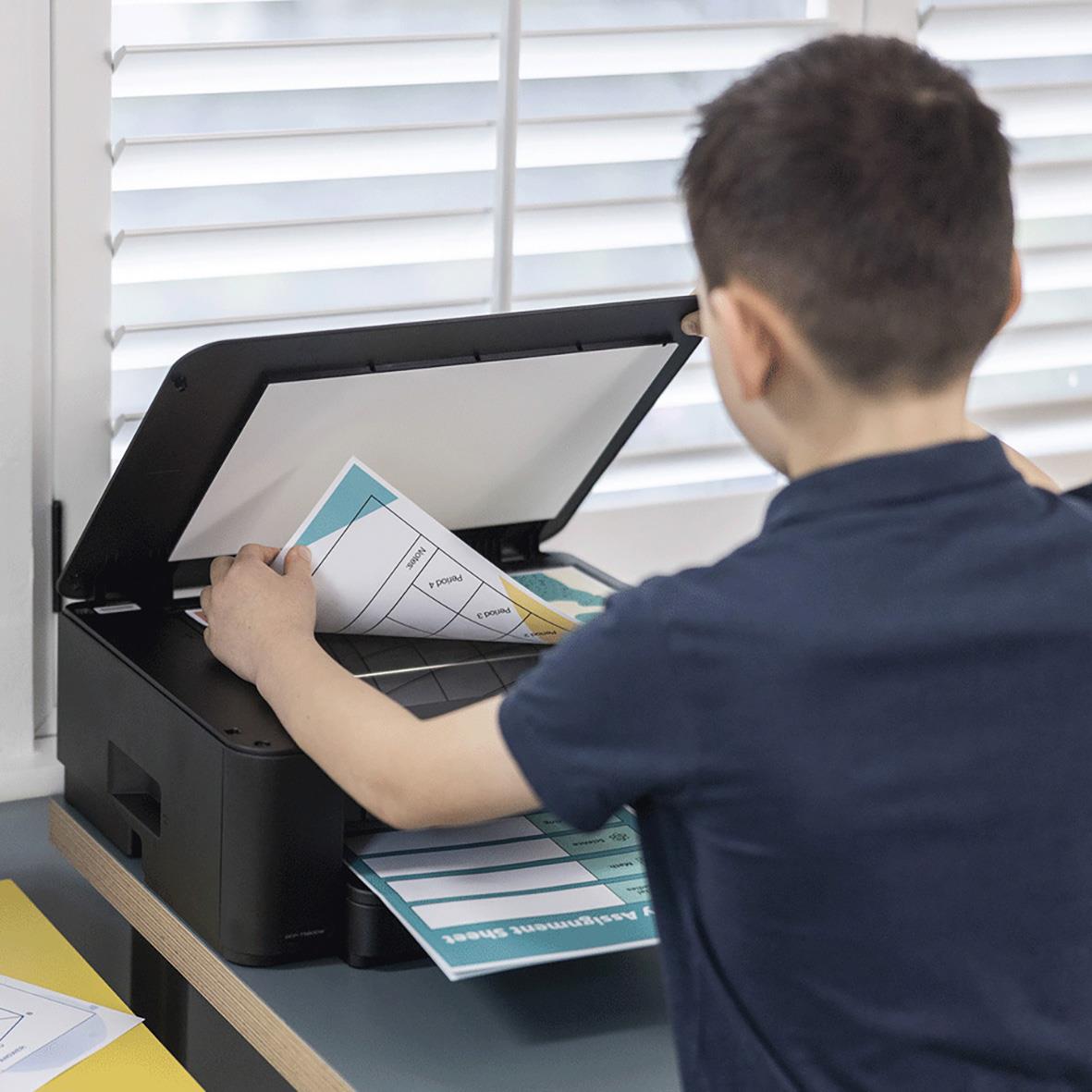 Ung person använder en multifunktionsskrivare Brother DCP-T580DW för att skanna eller skriva ut dokument