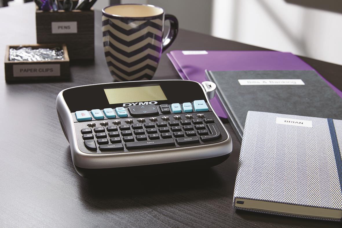 Dymo LabelManager 360D märkmaskin på skrivbord med anteckningsböcker och kopp