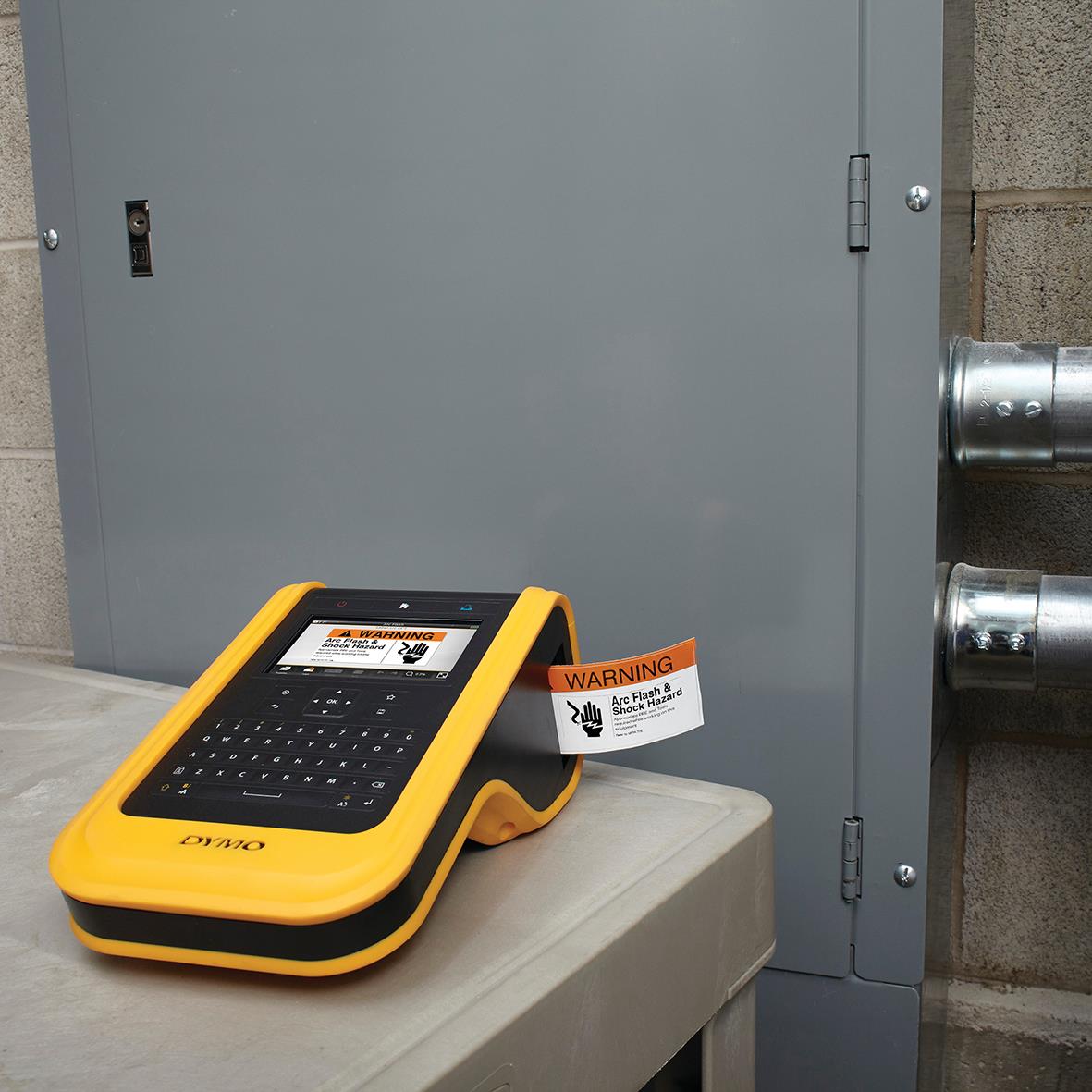 Märkmaskin Dymo XTL 500 i gul och svart väska på en bänk