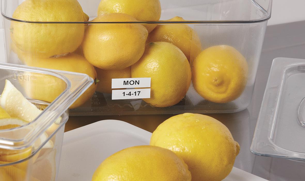 Låda med gula citroner och ett märkbandsrulle Dymo D1 19mm x 7m Svart/Vit