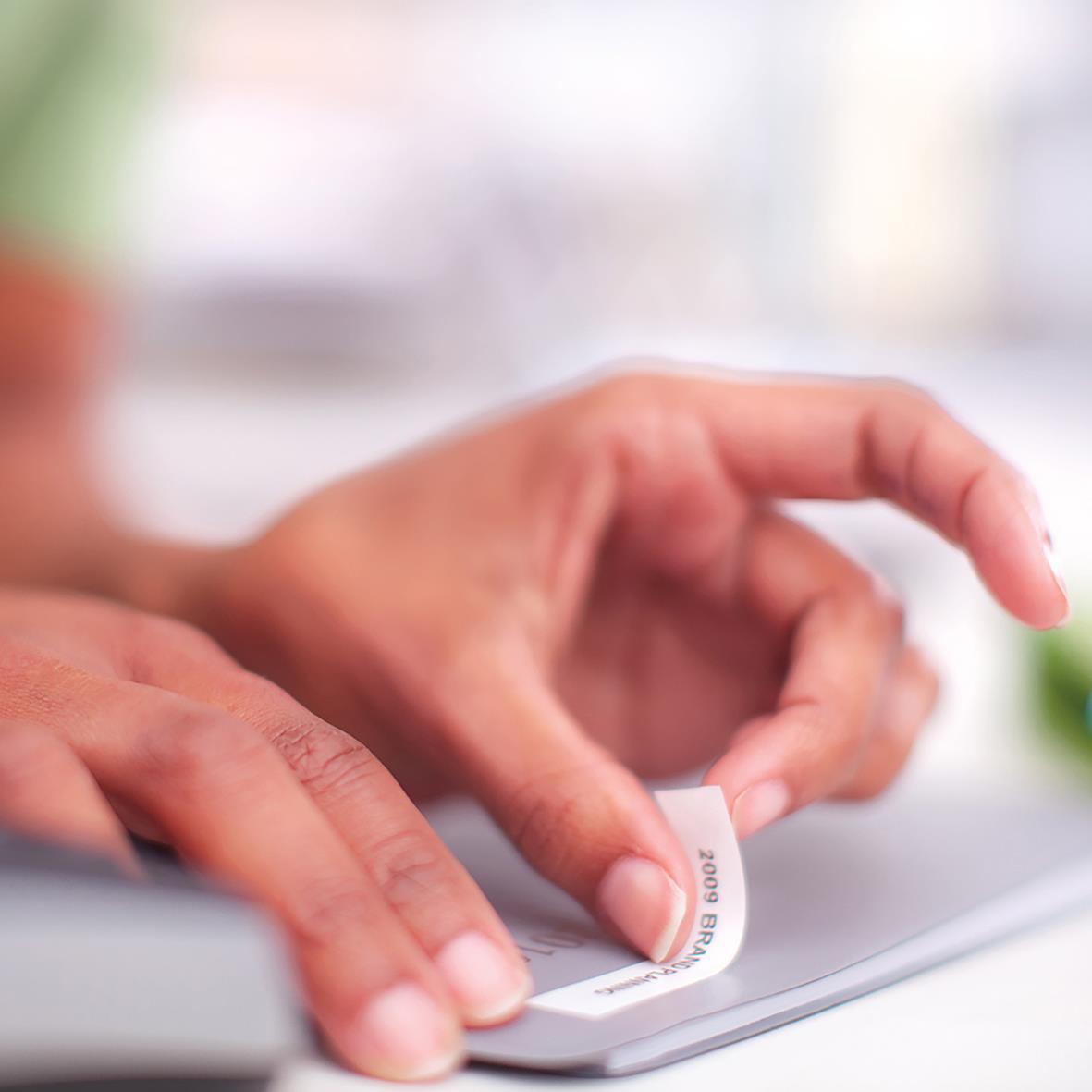 Person som använder en Dymo D1 7m svart/vit etikett för märkning