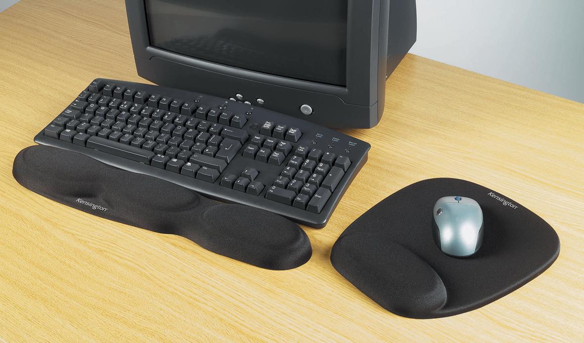 Handledsstöd Kensington Foam svart framför en dator med tangentbord och mus på ett träbord
