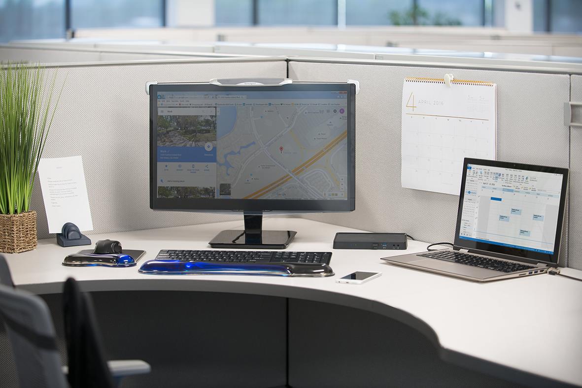 Arbetsplats med två skärmar, tangentbord, mus och kontorsmaterial på skrivbordet