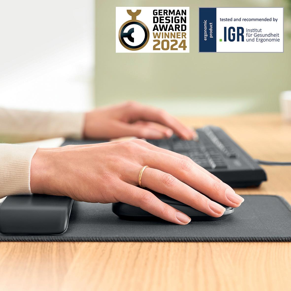 Hand som använder justerbar handledsstöd med musmatta i mörkgrå på skrivbord