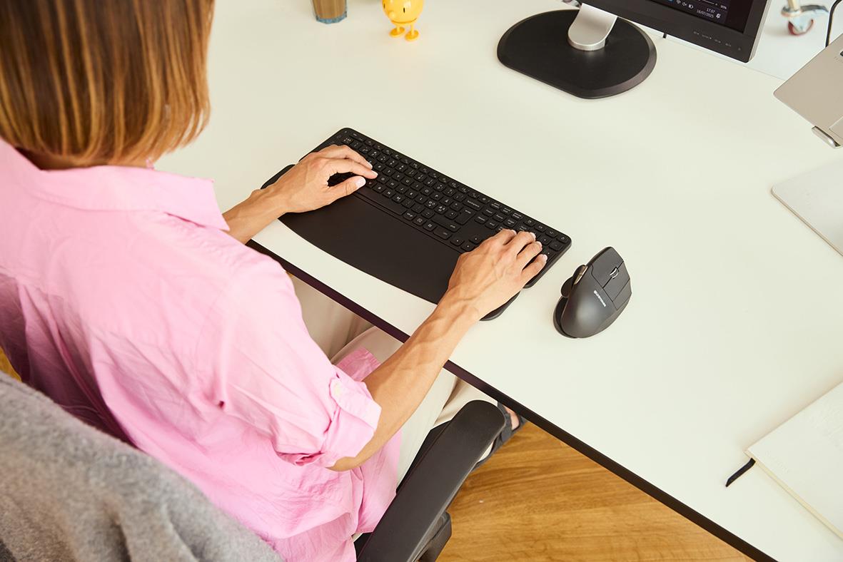 Person som använder handledsstöd Contour Balance Full-Size vid skrivbordet