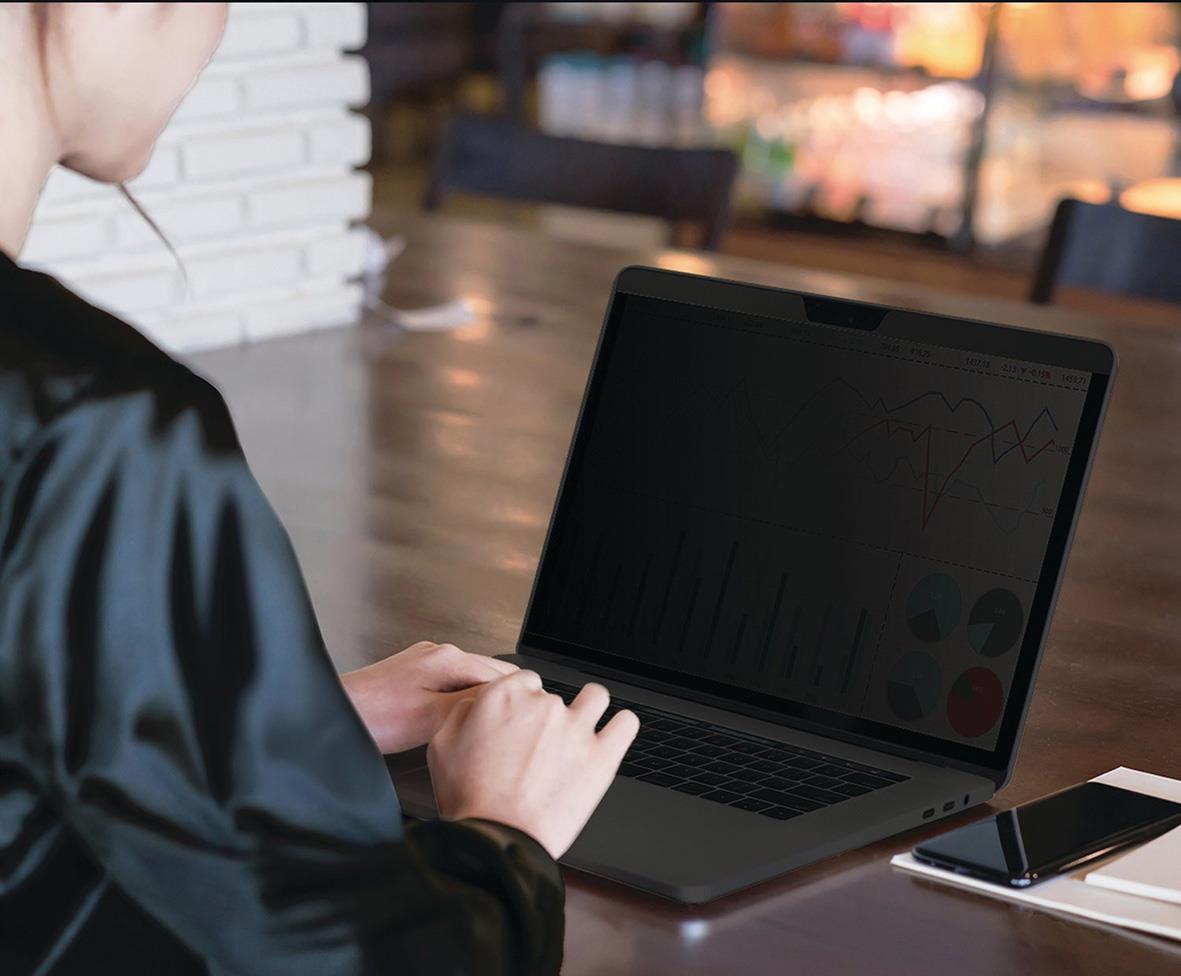 Person använder en Kensington 16-tums laptopsekretessfilter på en öppen laptop i ett kafé eller kontorsmiljö