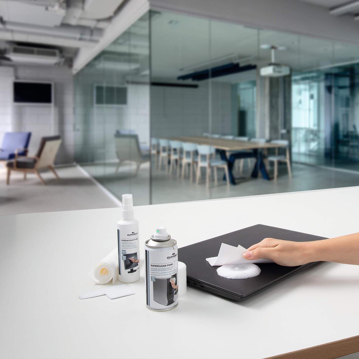 Rengöringsset för datorer på ett kontorsbord med rengöringsprodukter och trasa