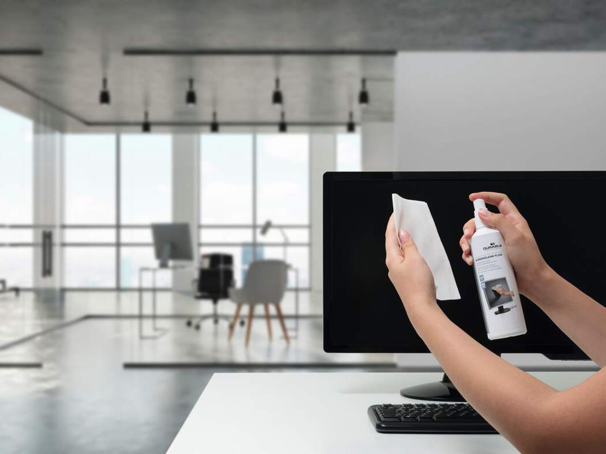 Person rengör en datorskärm med Durable Screenclean 250ml i ett modernt kontorsutrymme