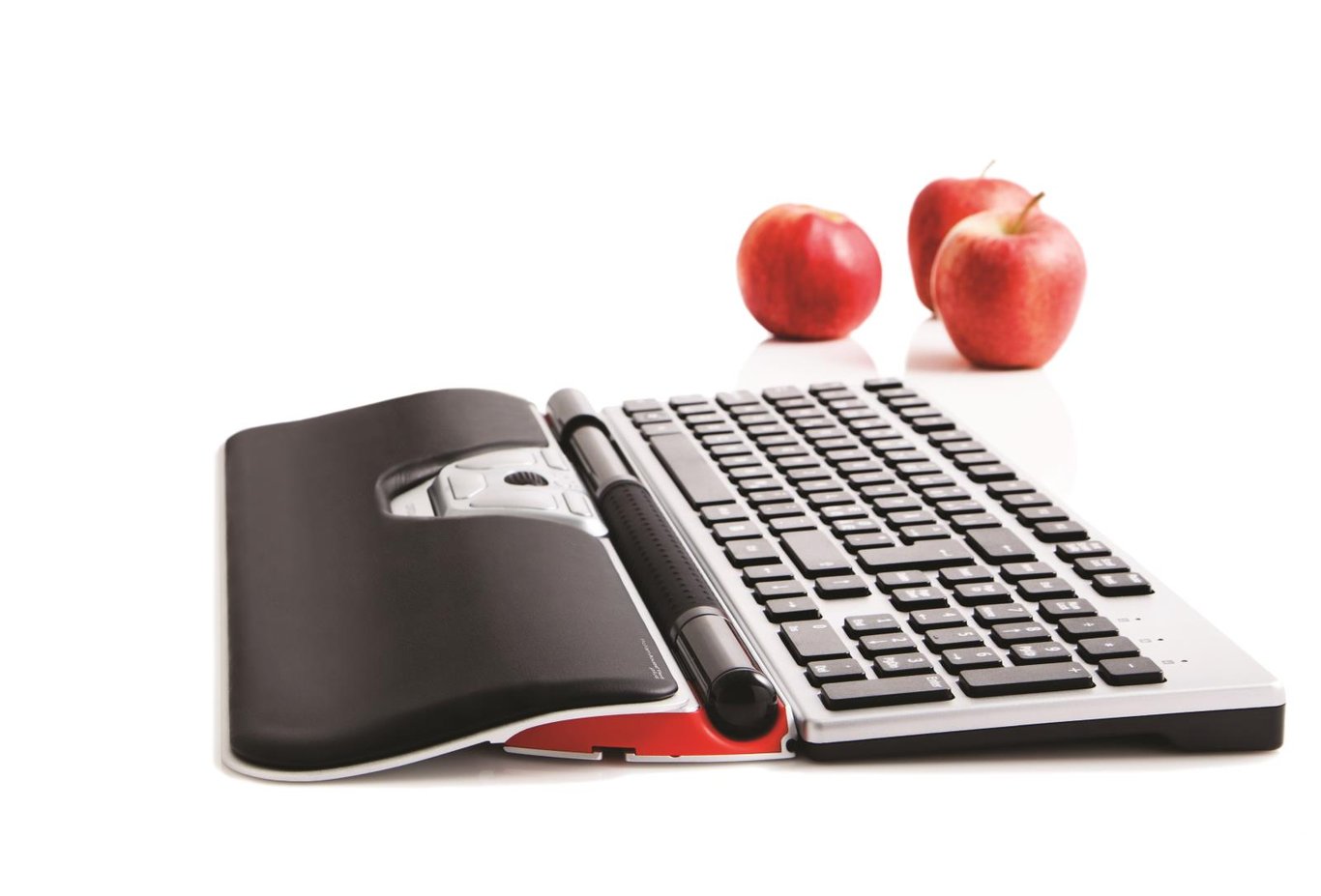 Ergonomisk mus RollerMouse Red Plus med sladd, placerad framför ett tangentbord med tre äpplen i bakgrunden