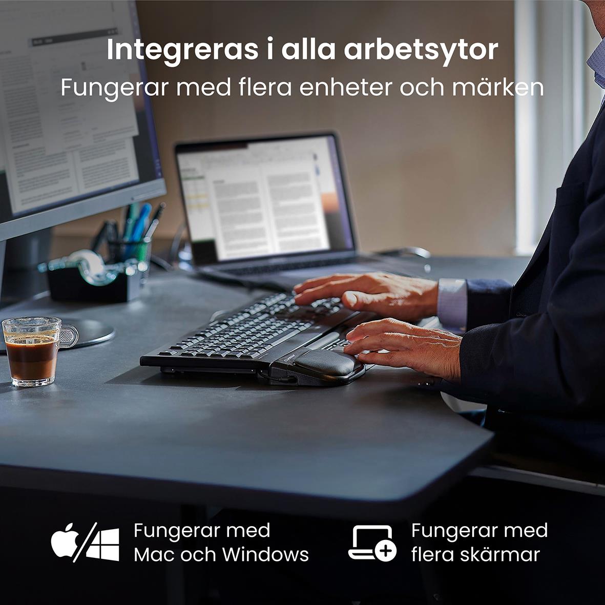 Person som använder en ergonomisk mus på ett kontor med dator och skärmar