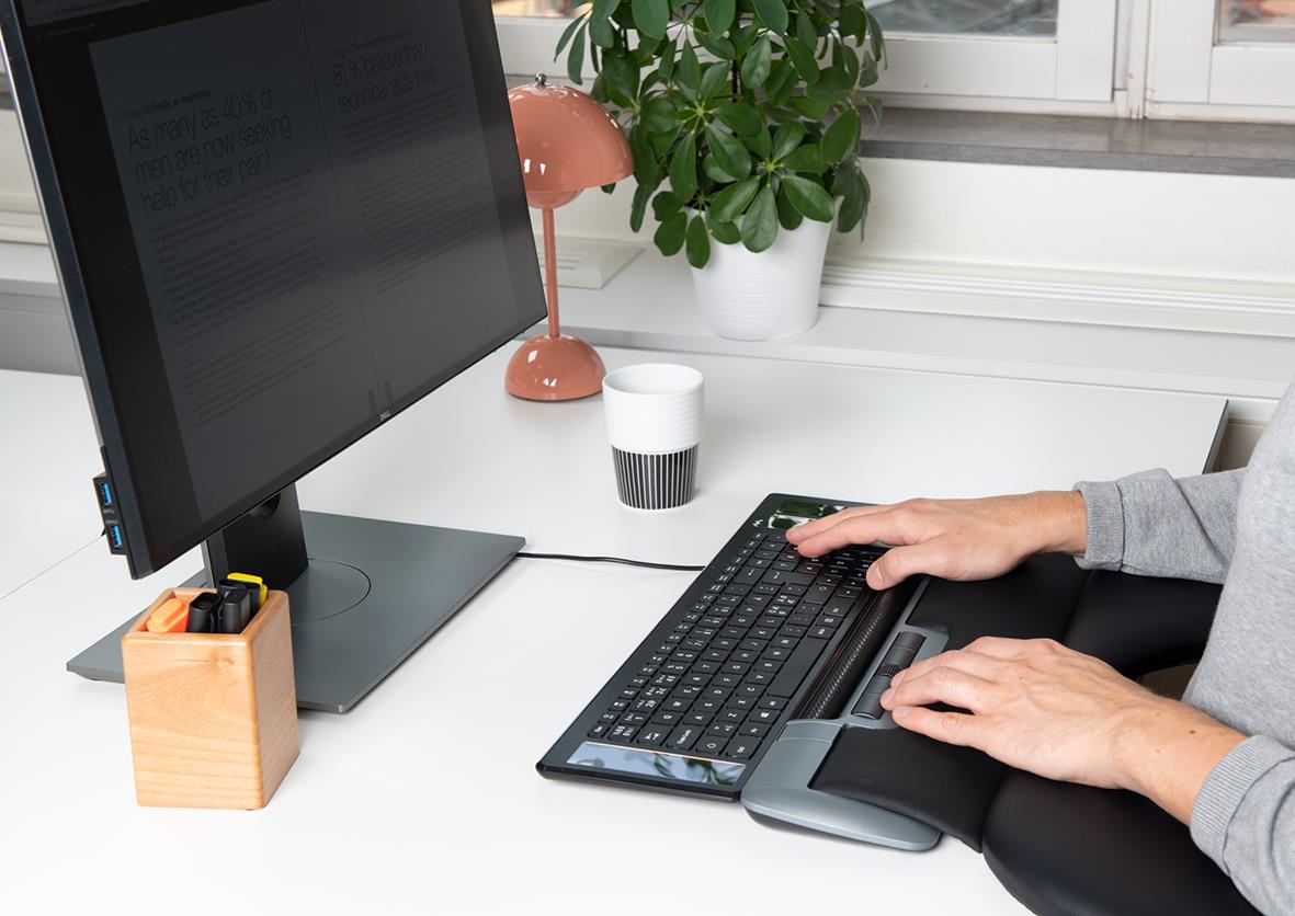 Person som använder en ergonomisk mus Mousetrapper Delta Extended vid skrivbordet