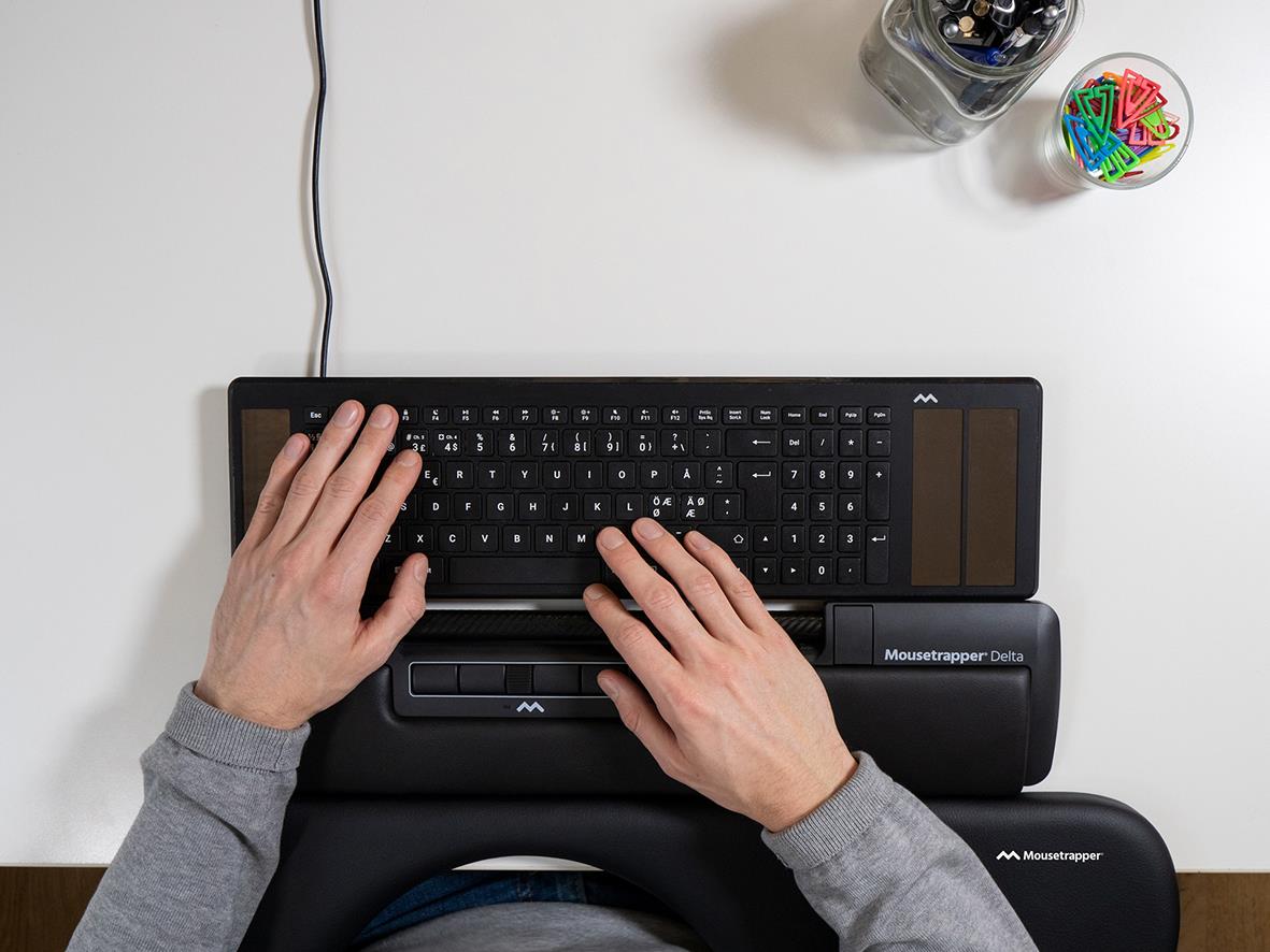 Person använder en ergonomisk mus Mousetrapper Delta på ett skrivbord